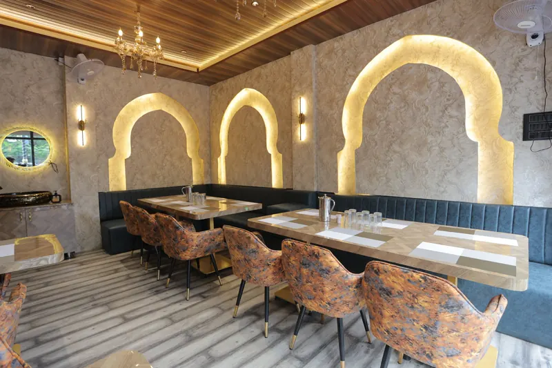 Dining hall at Casamia with glowing Mughal arches and chandelier